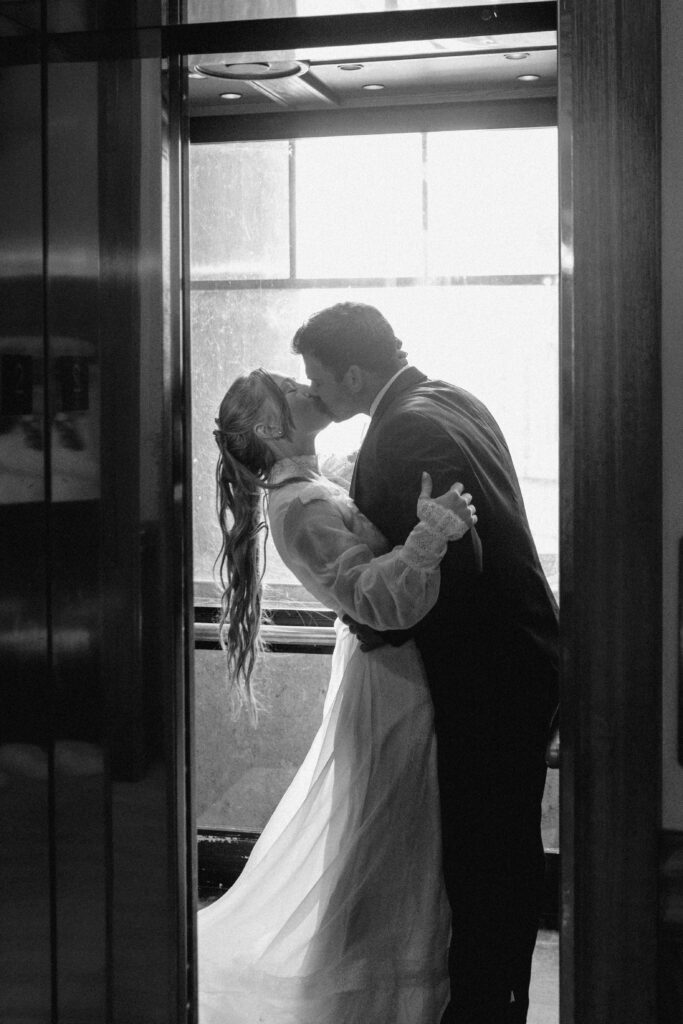bride and groom kissing in elevator