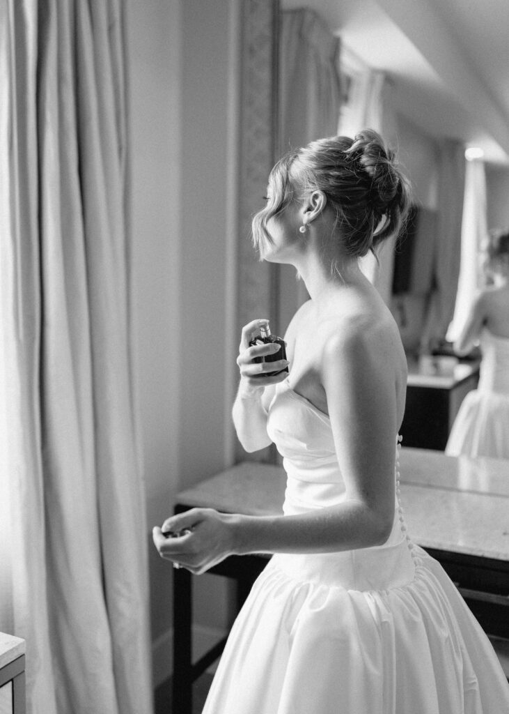 bride spraying perfume for wedding day at Hotel Syracuse